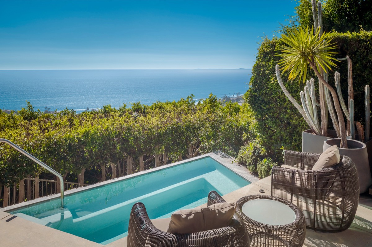 Pool with wicker lounge chairs and landscaping